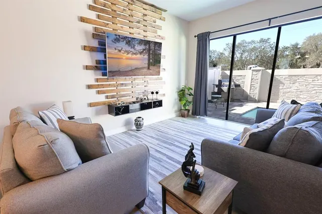 a living room with furniture wooden floor and a flat screen tv