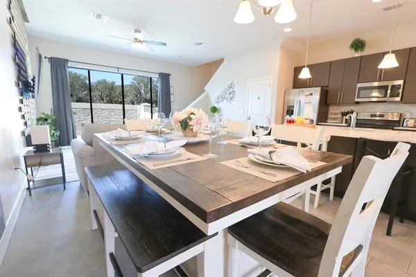 a view of a dining room and livingroom with furniture wooden floor a rug and a chandelier