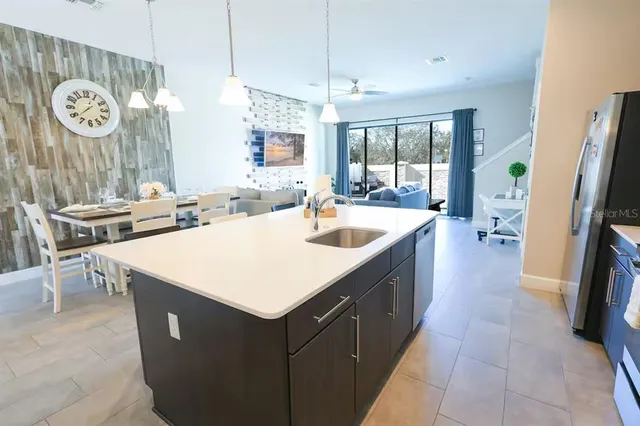 a large residential kitchen with a large window a sink and stainless steel appliances