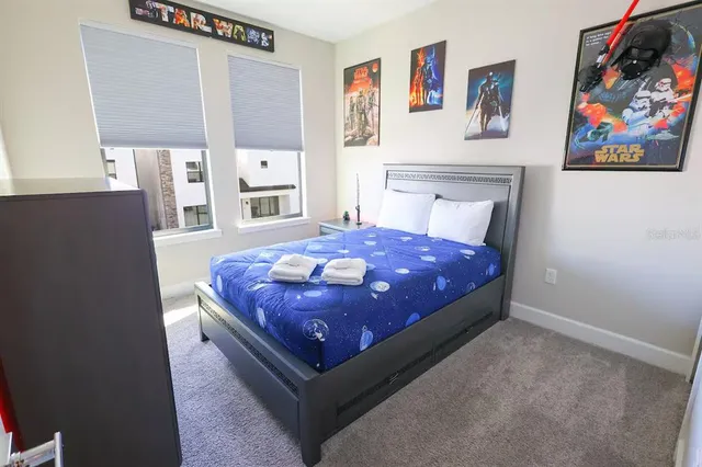 a large bed sitting in a bedroom next to a window