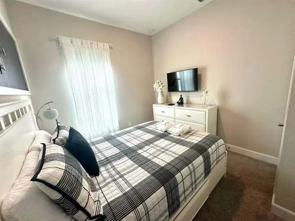 a bedroom with a bed and a flat screen tv
