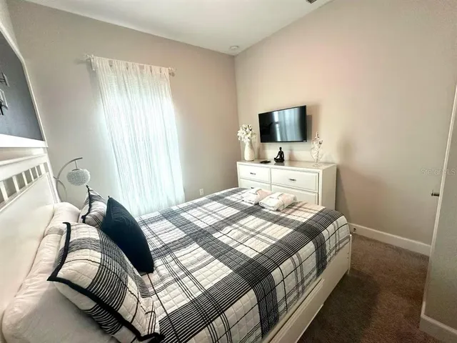 a bedroom with a bed and a flat screen tv