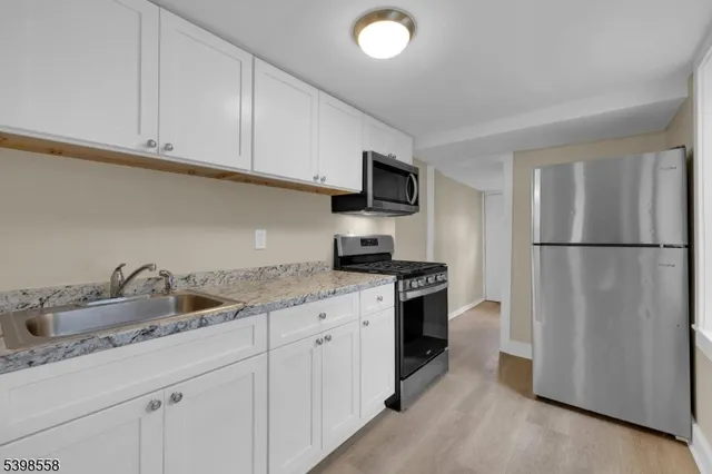 a kitchen with appliances a sink and cabinets