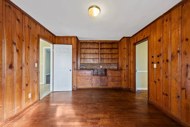 a view of empty room with wooden floor and entryway