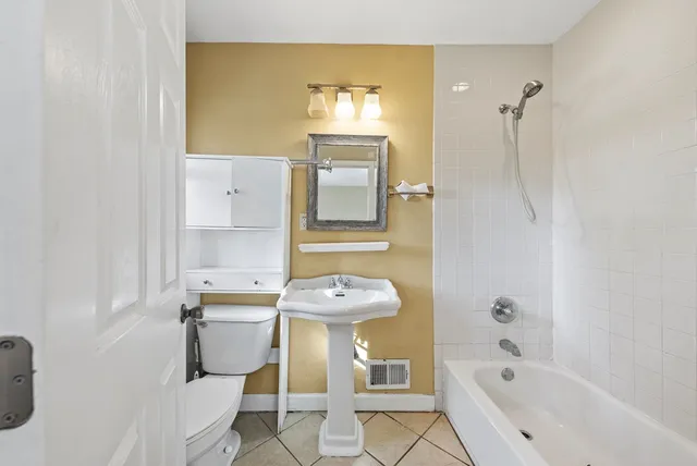 a bathroom with a sink mirror toilet and bathtub