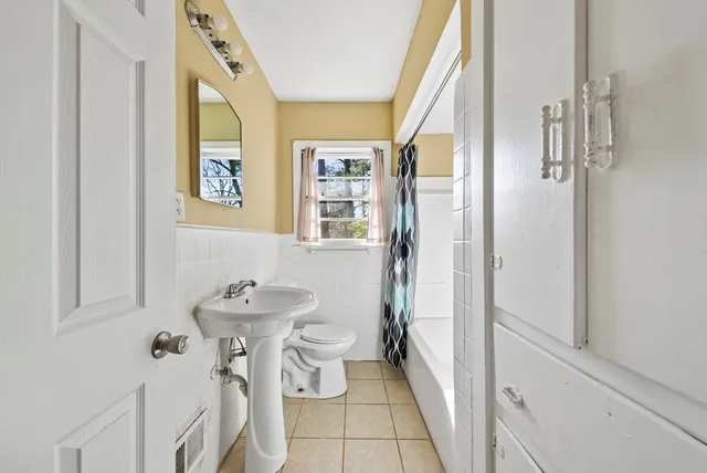 a bathroom with a sink mirror and toilet
