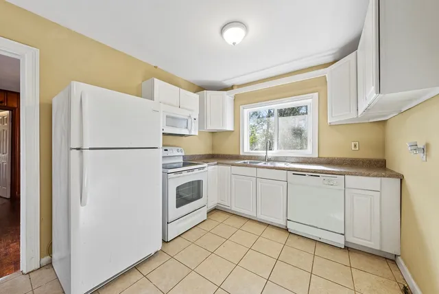 a kitchen with granite countertop appliances a sink and a refrigerator