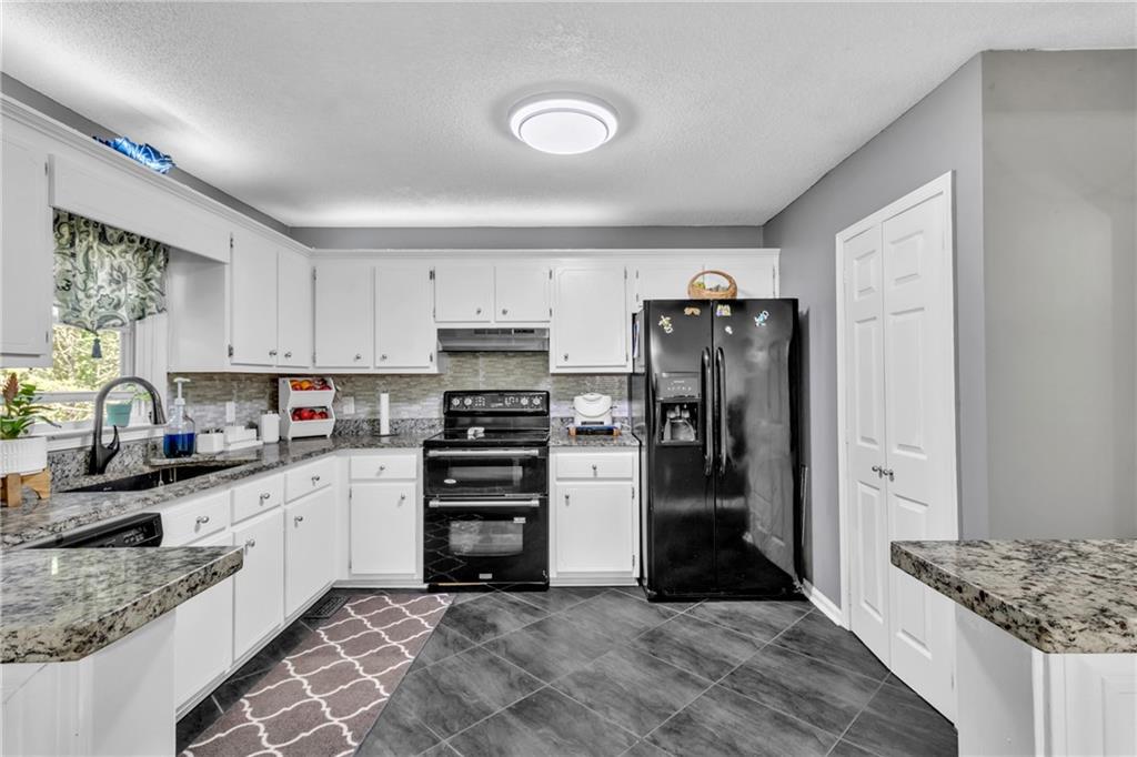 12 Ranger Road Southeast Cartersville, GA 30121 - Photo 13 of 51 a kitchen with stainless steel appliances kitchen island granite countertop a refrigerator and a sink