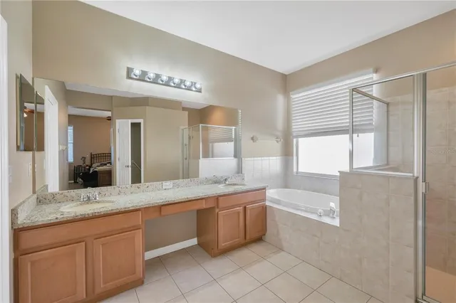a spacious bathroom with a granite countertop sink mirror and bathtub