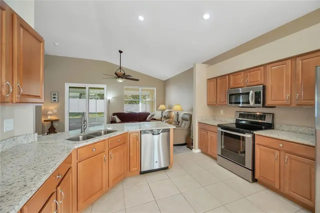 a kitchen with stainless steel appliances granite countertop a sink and dishwasher a stove top oven with wooden floor