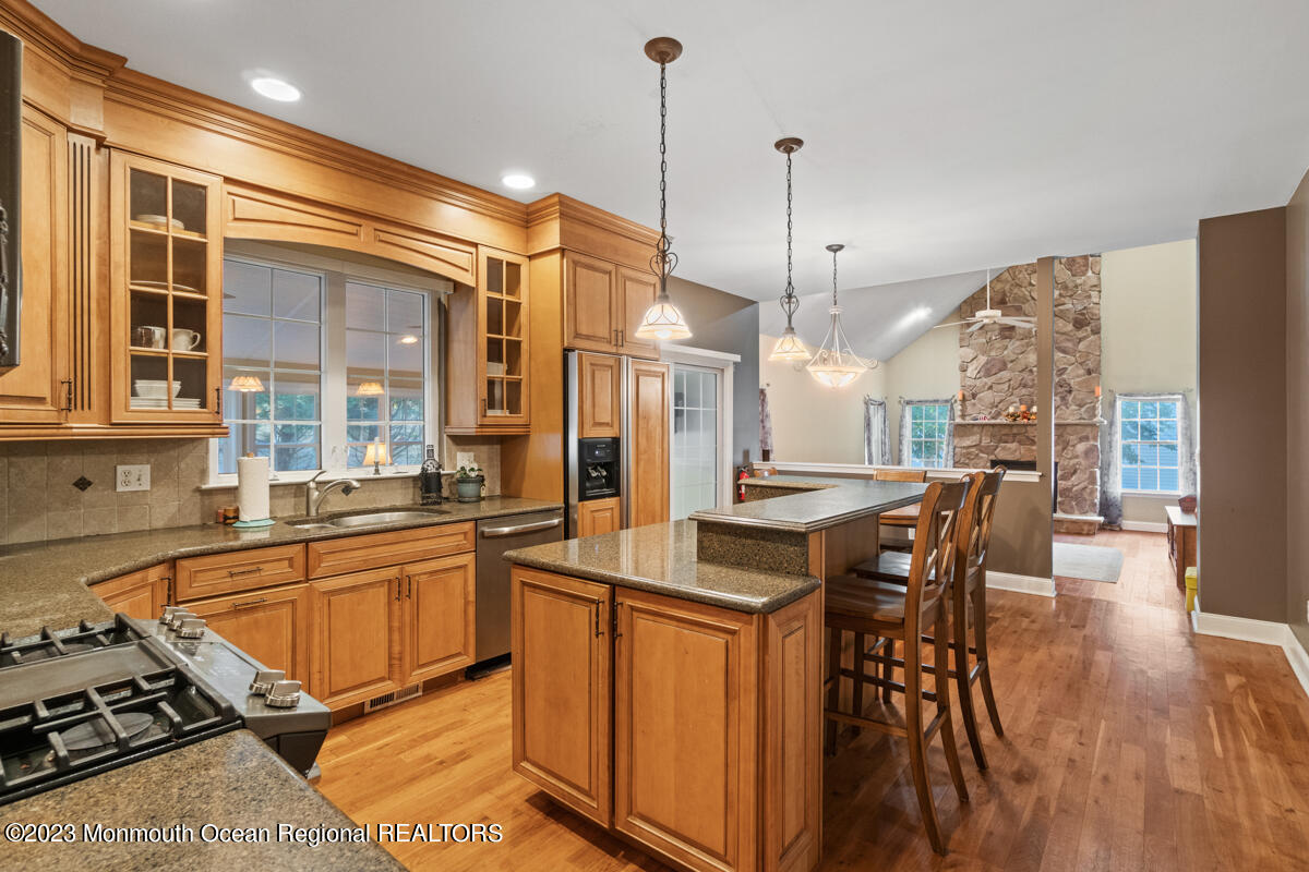 6 Forest View Drive Bayville, NJ 08721 - Photo 21 of 39 a kitchen with stainless steel appliances granite countertop a stove a sink a refrigerator a dining table and chairs with wooden floor