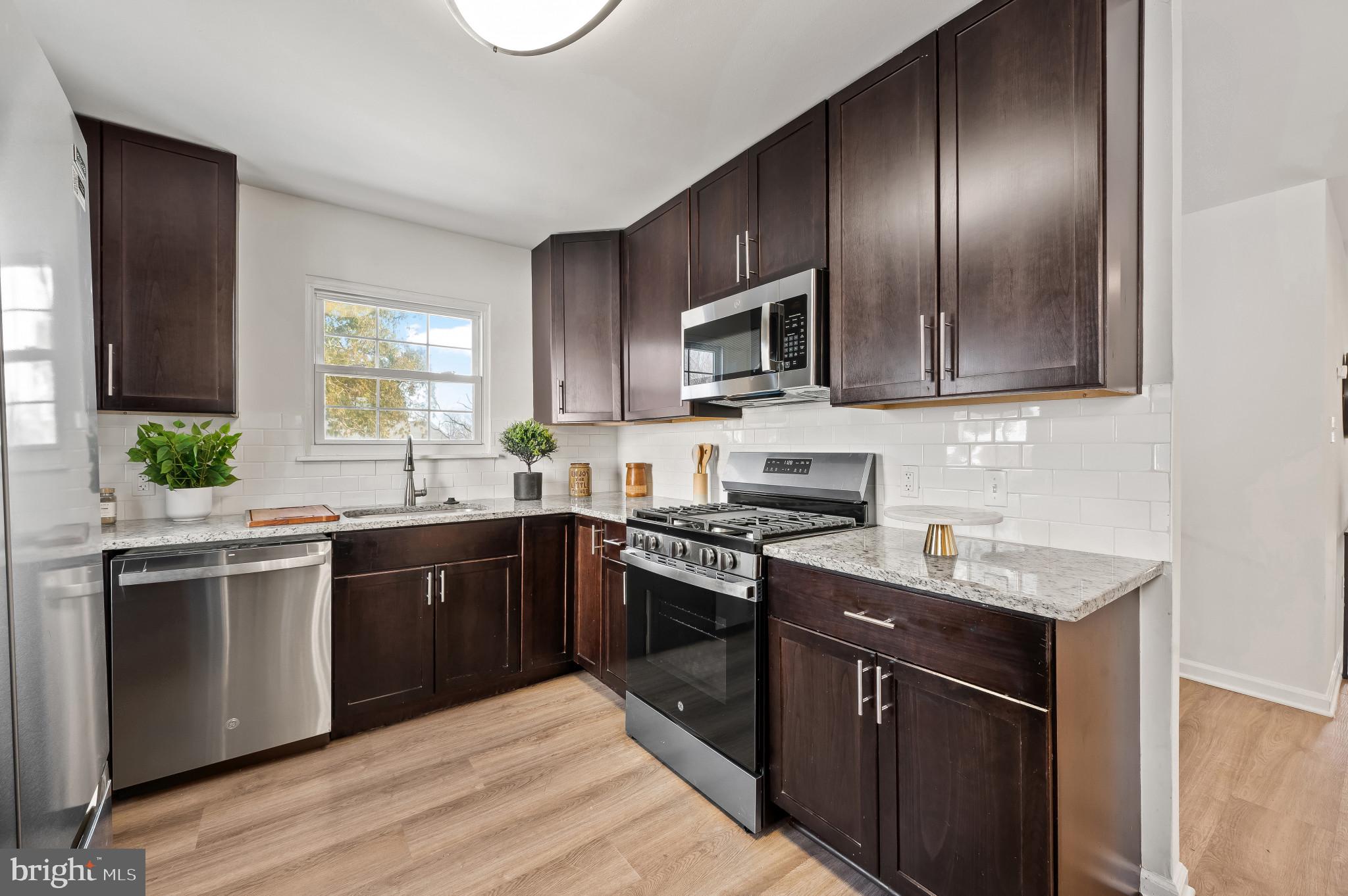 200 Timber Grove Road Reisterstown, MD 21136 - Photo 2 of 30 a kitchen with stainless steel appliances granite countertop a sink stove microwave and refrigerator