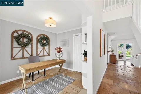 a view of a hallway with wooden floor and furniture
