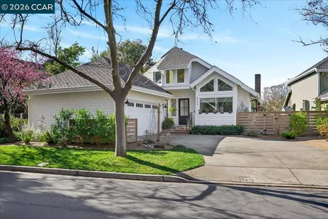 a front view of a house with a yard and potted plants