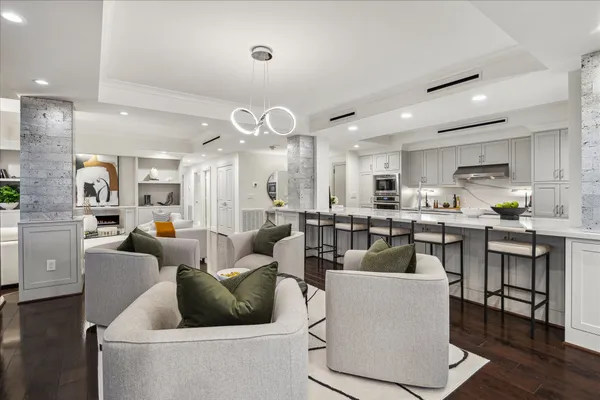 a living room with furniture kitchen and a chandelier