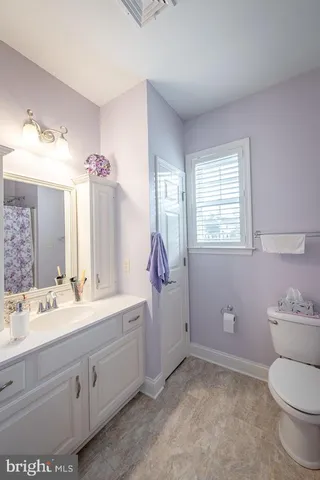 a spacious bathroom with a toilet sink and mirror