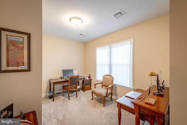 a living room with furniture a desk and chair with windows