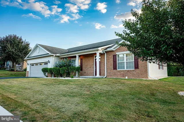 a front view of a house with a yard and trees