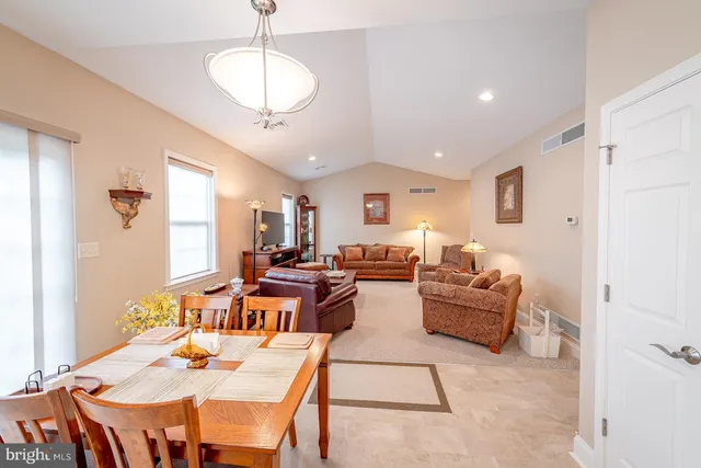 a living room with furniture kitchen view and a chandelier