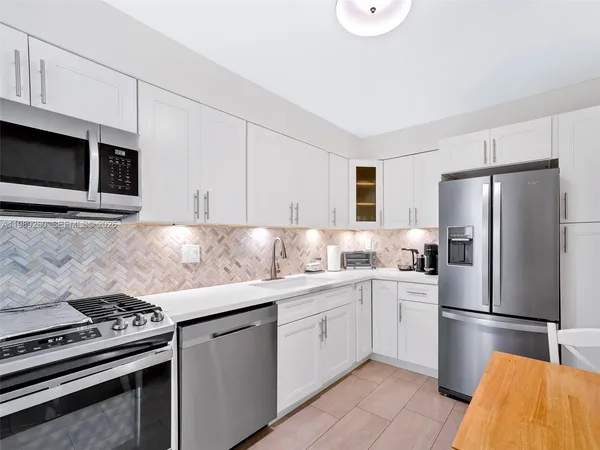 a kitchen with stainless steel appliances a stove a sink and a refrigerator