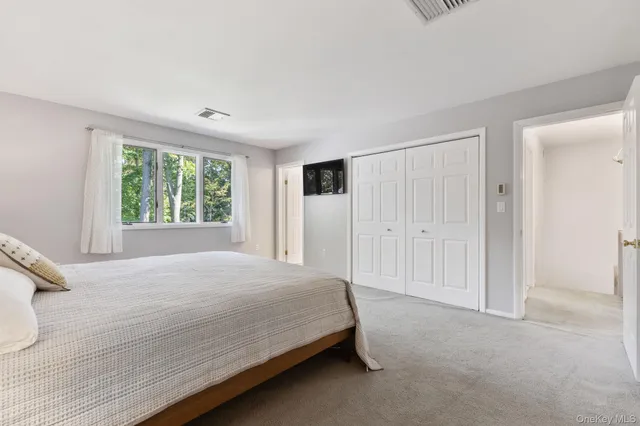 a bedroom with a large bed closet and window