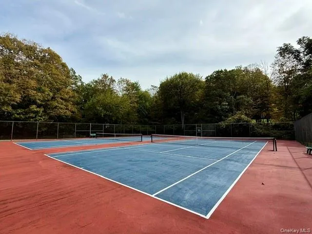 a view of tennis court with large trees