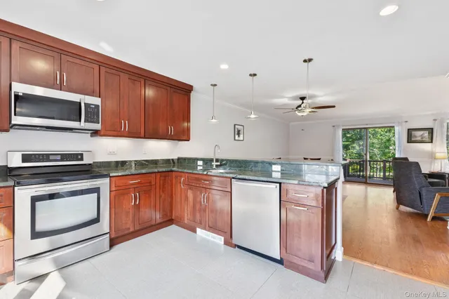 a kitchen with granite countertop kitchen island stainless steel appliances a stove sink microwave and cabinets