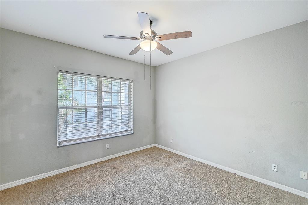 8358 Bernwood Cove Loop, Unit 708 Fort Myers, FL 33966 - Photo 18 of 32 an empty room with chandelier fan and windows