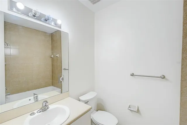 a bathroom with a sink mirror vanity and toilet
