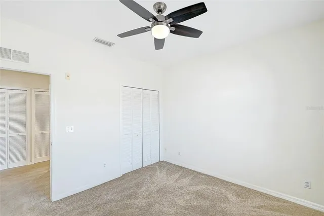 an empty room with a ceiling fan and a window