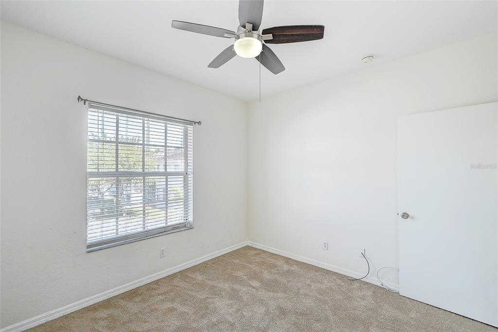 8358 Bernwood Cove Loop, Unit 708 Fort Myers, FL 33966 - Photo 25 of 32 an empty room with windows and fan