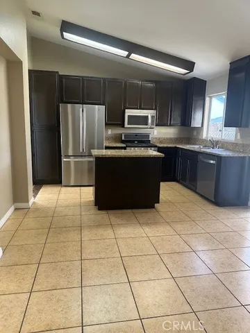 a kitchen with stainless steel appliances granite countertop a refrigerator and a stove