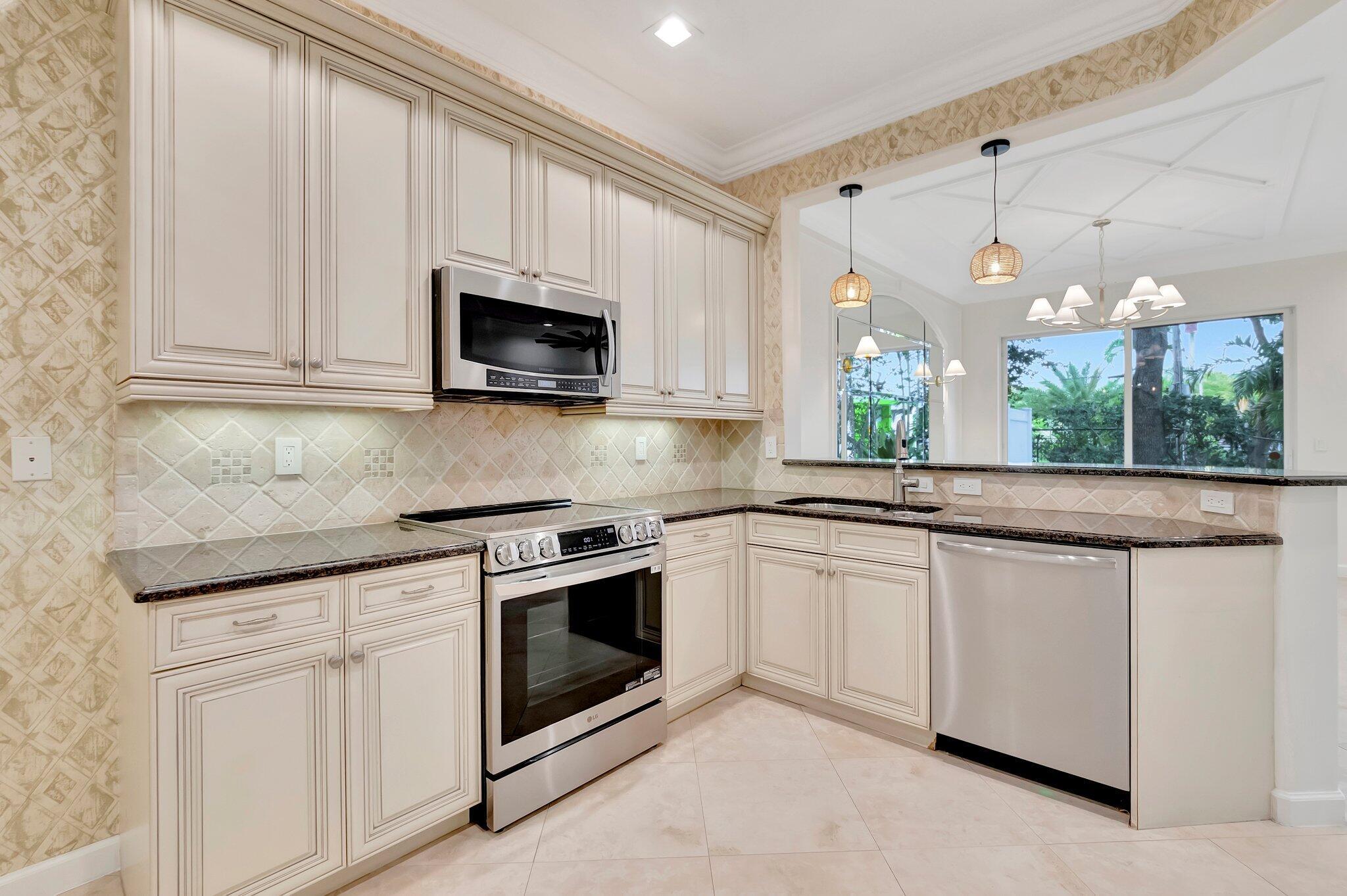 100 West Prive Circle Delray Beach, FL 33445 - Photo 18 of 43 a kitchen with granite countertop white cabinets white stainless steel appliances and a sink