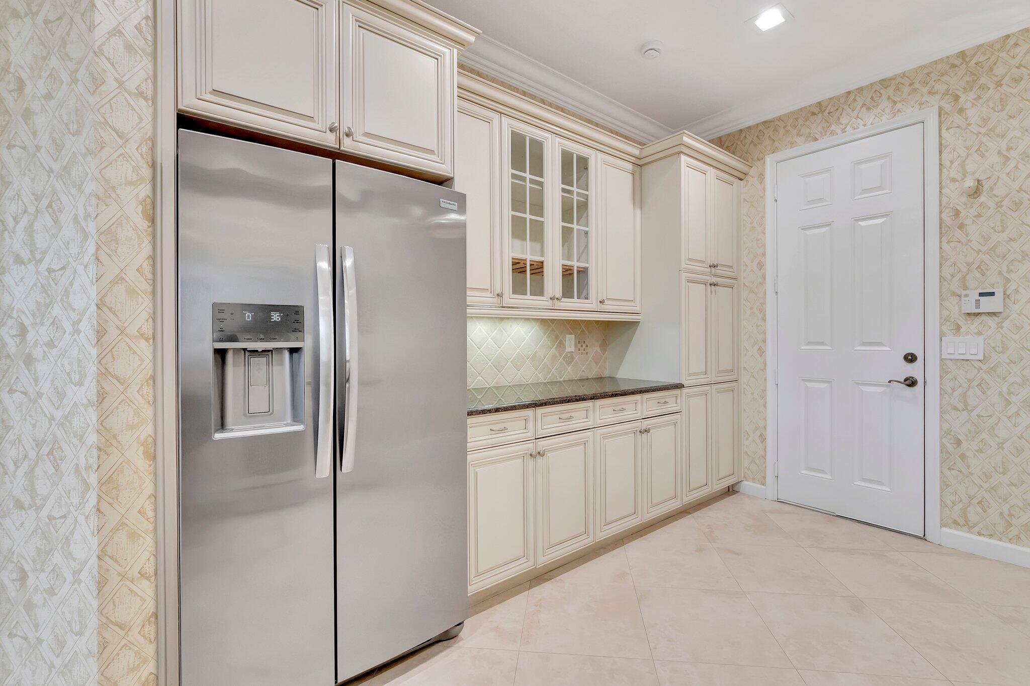 100 West Prive Circle Delray Beach, FL 33445 - Photo 19 of 43 a kitchen with stainless steel appliances granite countertop a refrigerator and white cabinets