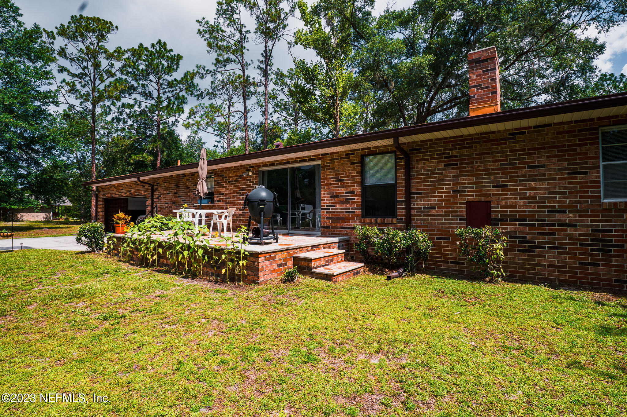 3991 Bronco Road Middleburg, FL 32068 - Photo 33 of 41 a view of a patio with table and chairs potted plants and large tree