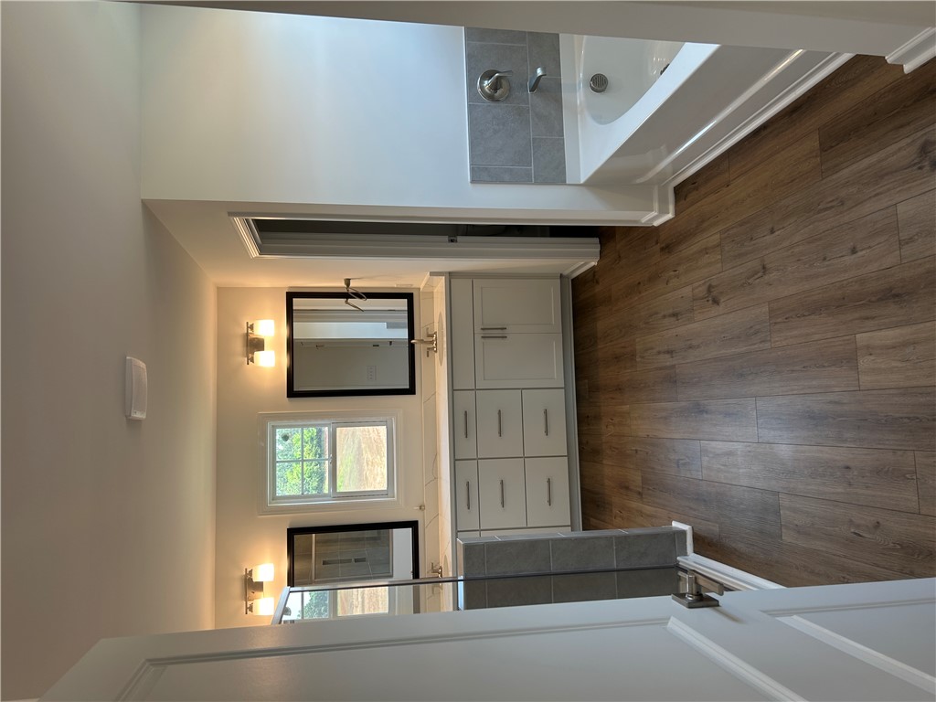 211 Bellflower Lane Anderson, SC 29625 - Photo 18 of 28 A well-lit bathroom features a deep soaking tub and a spacious vanity with dual mirrors.