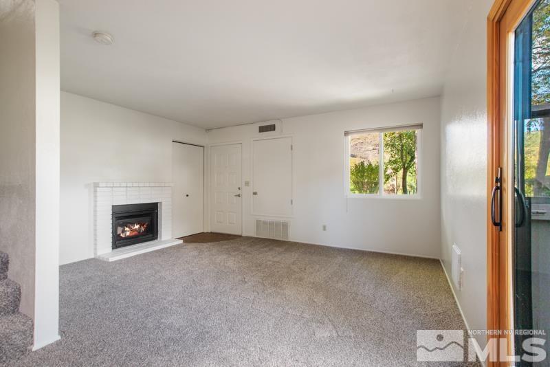 4853 Reggie Road Reno, NV 89502 - Photo 3 of 27 an empty room with windows and fireplace