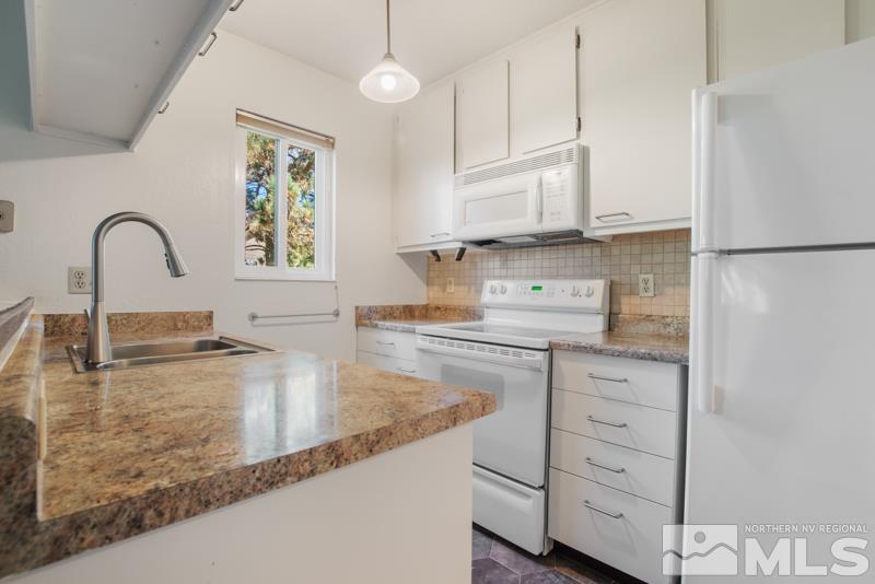 4853 Reggie Road Reno, NV 89502 - Photo 4 of 27 a kitchen with granite countertop a sink stainless steel appliances and cabinets