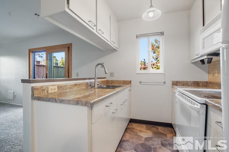 4853 Reggie Road Reno, NV 89502 - Photo 5 of 27 a kitchen with stainless steel appliances granite countertop a sink and a refrigerator