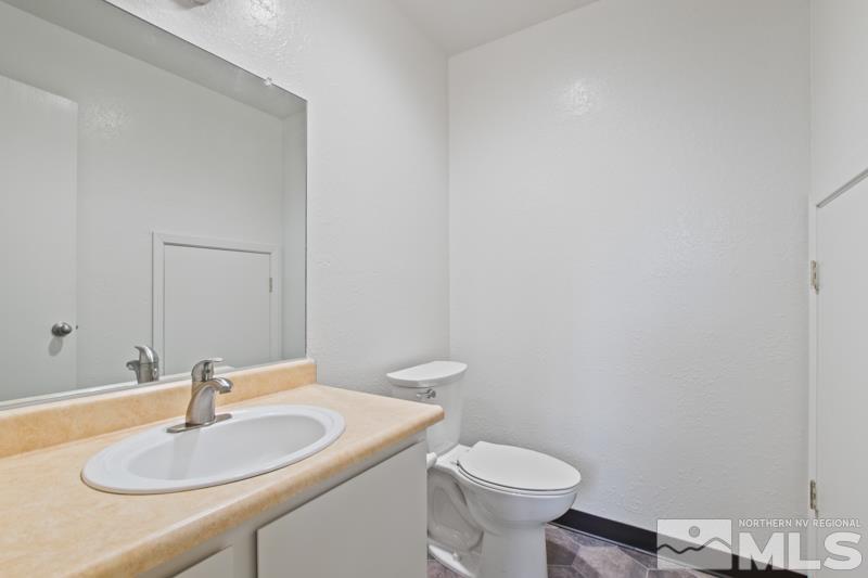 4853 Reggie Road Reno, NV 89502 - Photo 6 of 27 a bathroom with a sink a toilet and a mirror