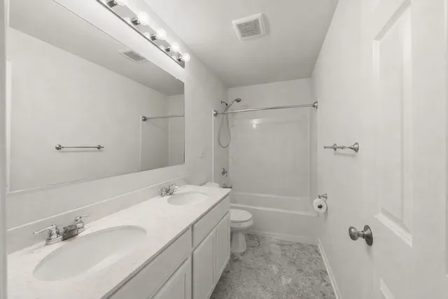 a bathroom with a double vanity sink toilet mirror and shower