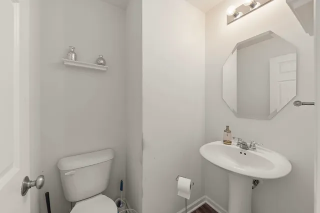 a bathroom with a toilet sink and mirror