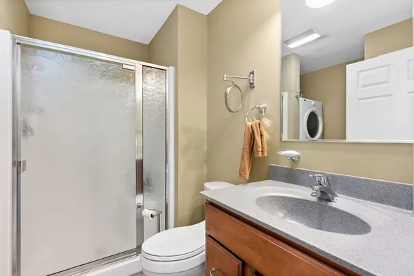 a bathroom with a granite countertop sink toilet and shower