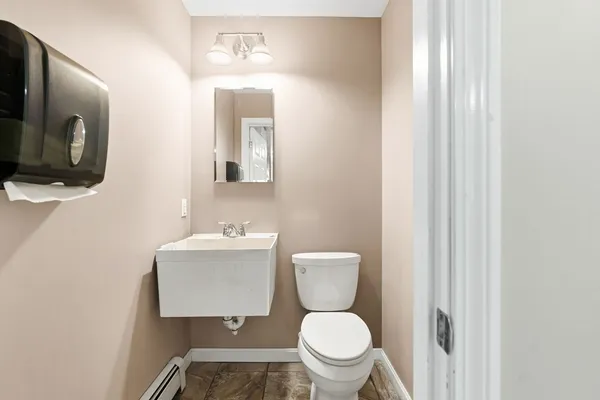 a bathroom with a toilet a sink and mirror