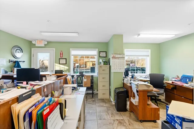 a view of a workspace with furniture and a window