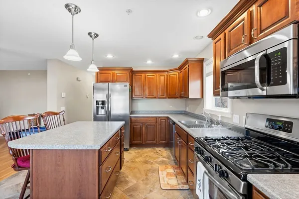 a kitchen that has a lot of cabinets in it and stainless steel appliances