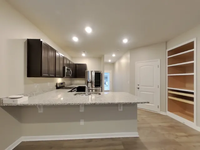 a large kitchen with kitchen island granite countertop a large counter top stainless steel appliances and cabinets