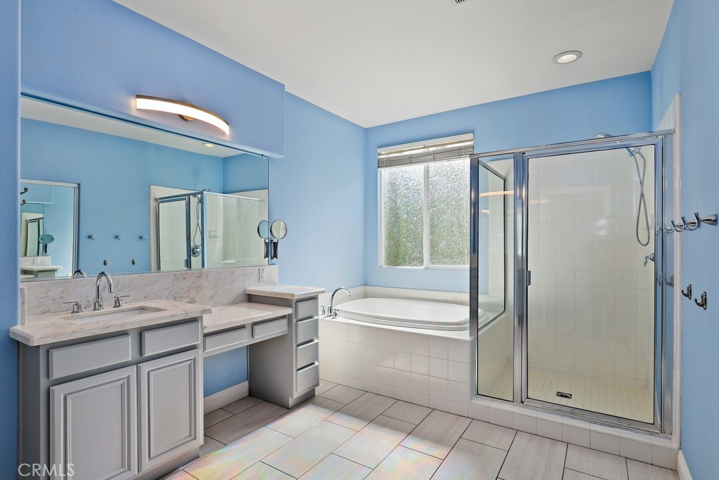 31319 Locust Court Temecula, CA 92592 - Photo 34 of 75 a bathroom with a granite countertop sink mirror and a bathtub