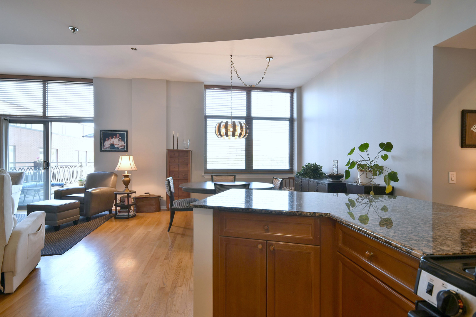 1201 West Adams Street, Unit 411 Chicago, IL 60607 - Photo 12 of 40 a kitchen with granite countertop a sink dishwasher a dining table and chairs with wooden floor