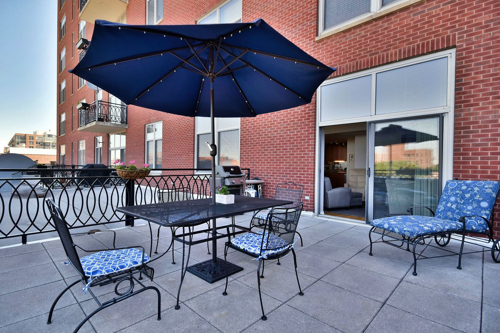 1201 West Adams Street, Unit 411 Chicago, IL 60607 - Photo 35 of 40 a patio table and chairs under an umbrella